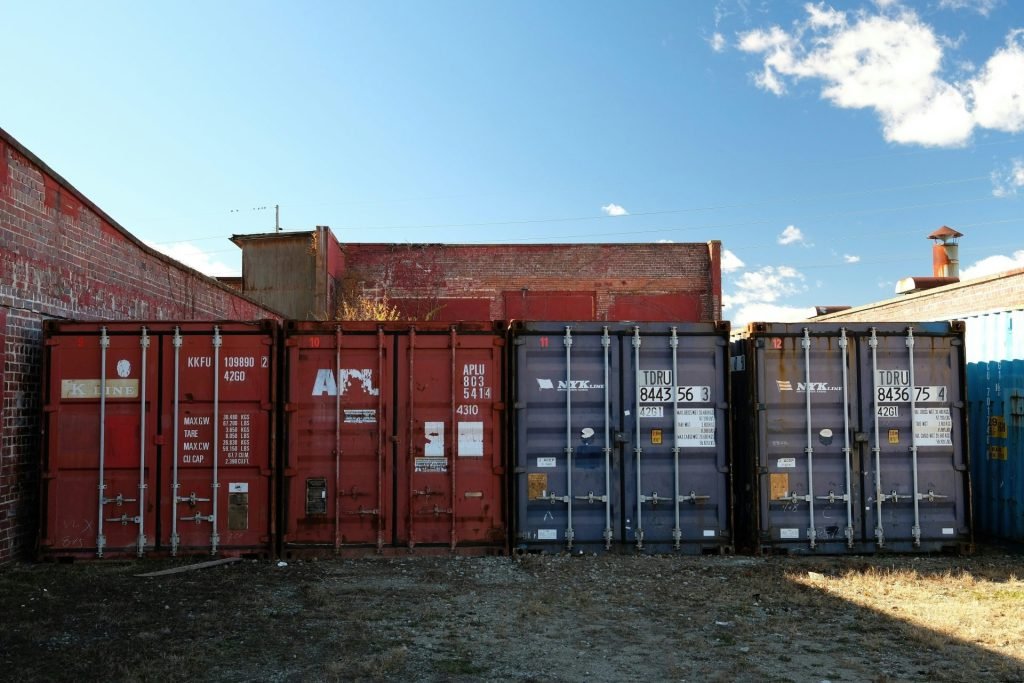 Shipping containers lined up against brick buildings
